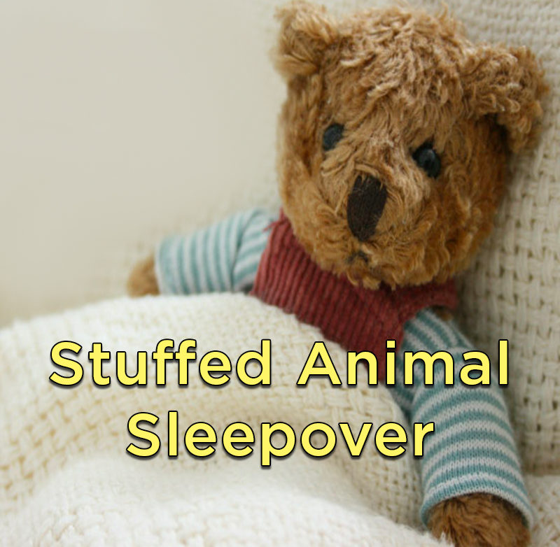 Teddy bear wearing pajamas tucked under a blanket